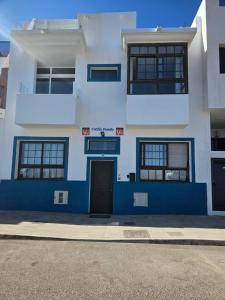 un bâtiment bleu et blanc avec une porte à l'avant dans l'établissement Apartamentos Cotillo Family, à El Cotillo