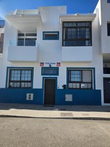 un edificio blu e bianco con una porta di fronte di Apartamentos Cotillo Family a Cotillo