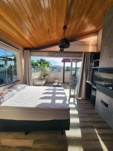 a bedroom with a large bed with a wooden ceiling at Casamar Lofts Praia dos Anjos 03 in Arraial do Cabo