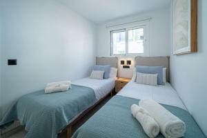 two beds in a room with blue and white at Casa Boga in Puerto del Carmen