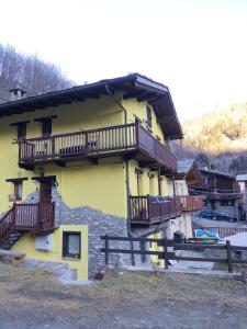un edificio amarillo con balcones en un lateral en Maison du Soleil- CIR VDA Valtournenche n 0204, en Valtournenche