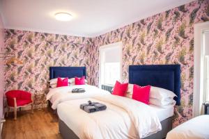 2 camas num quarto com papel de parede floral em Liverpool Georgian Quarter Townhouse Rodney St em Liverpool