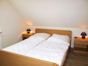 een bed in een kamer met twee lampen op twee tafels bij Holiday Home Möwen und Muschel Nest by Interhome in Ostseebad Karlshagen