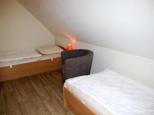 een kleine kamer met een bed en een stoel bij Holiday Home Möwen und Muschel Nest by Interhome in Ostseebad Karlshagen