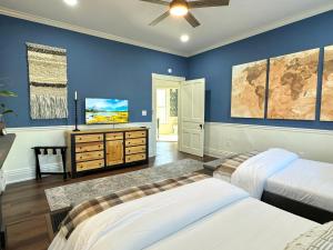 a bedroom with two beds and a tv on the wall at Garden on Capital-Bourbon & Horse Country in Frankfort
