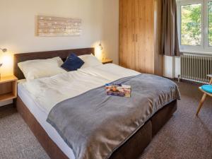 een slaapkamer met een groot bed met een boek erop bij Holiday Home Penz - FGZ151 by Interhome in Pankrazberg