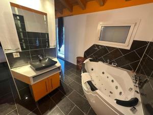 ein Badezimmer mit einer Badewanne und einem Waschbecken in der Unterkunft Charming Family Home Our Valais Bliss in Saint-Germain