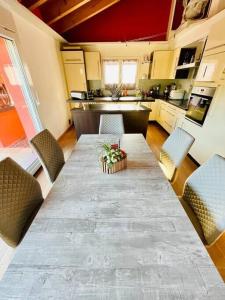 eine Küche mit einem langen Tisch mit Stühlen und einer Küche in der Unterkunft Charming Family Home Our Valais Bliss in Saint-Germain