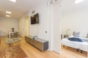 1 dormitorio con 1 cama y TV en la pared en My Space Barcelona - 2 Bedroom Apartment in uptown, en Barcelona
