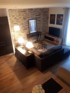 a living room with a couch and a brick wall at LE SQUARE in Luchon