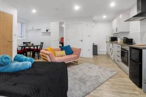 ein Wohnzimmer mit einem Sofa und einer Küche in der Unterkunft Exeter City Centre Apartments Riley Apartment in Exeter