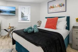 a bedroom with a bed with two stuffed animals on it at Exeter City Centre Apartments Riley Apartment in Exeter