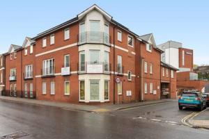 a red brick building with a car parked in front of it at Exeter City Centre Apartments Riley Apartment in Exeter