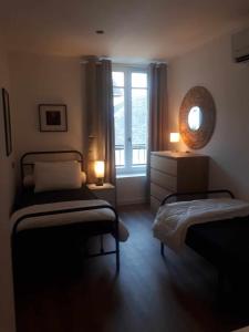 a bedroom with two beds and a window at LE SQUARE in Luchon