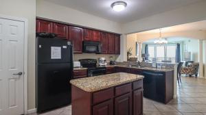 a kitchen with a black refrigerator and a counter top at Legacy II 603 Deluxe in Gulfport