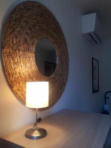 a lamp on a table with a round mirror at LE SQUARE in Luchon