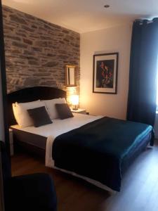 a bedroom with a large bed with a brick wall at LE SQUARE in Luchon