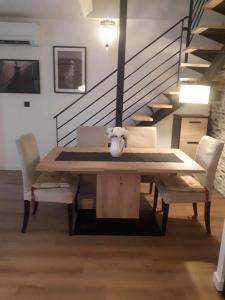 a dining room with a table and chairs and stairs at LE SQUARE in Luchon