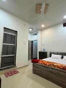 a bedroom with a bed in a room with a fan at Madhuri Guest House in Varanasi