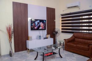 a living room with a couch and a glass table at Peace cottage short lets and apartments in Ibadan