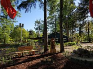 een park met een bank en bomen en een gebouw bij Camping Het Horstmannsbos in Gasselte