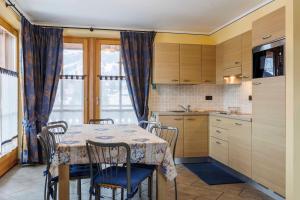 una cucina con tavolo e sedie e una cucina con finestra di Chalets Molin a Livigno