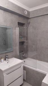 ein Badezimmer mit einer Dusche, einem Waschbecken und einer Badewanne in der Unterkunft Квартира в отличном районе с евро ремонтом in Almaty