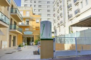 a building with a sign in the middle of a street at Residence Suite Smeraldo in Riccione