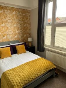 um quarto com uma cama com lençóis amarelos e uma janela em Most Easterly (North) em Pakefield