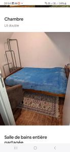 um quarto com uma cama com um cobertor azul e um tapete em Le Gîte des Korrigans em La Feuillée