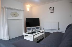 a living room with a tv and a couch at Large Capacity Comfortable Group Stay in Nottingham