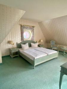 een slaapkamer met een groot bed en een raam bij Hotel am Markt Altentreptow in Altentreptow