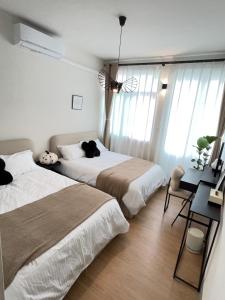 a bedroom with two beds and a desk and windows at 沐光冉冉 in Anping