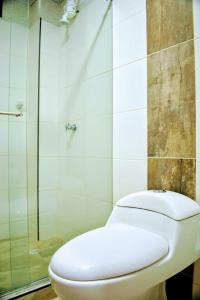 een badkamer met een toilet en een glazen douche bij hotel villa nazareth in Quimbaya