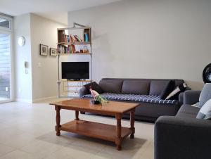 sala de estar con sofá y mesa de centro en Apartamento de 2 quartos a 3 minutos a pé da praia de Cachoeira de Bom Jesu com águas calmas, en Florianópolis