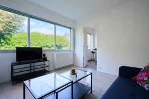 a living room with a couch and a tv at Functional studio+ Parking close to the tramway in Marquette-lès-Lille +24 photos