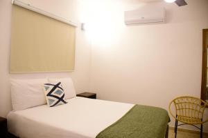 1 dormitorio con cama blanca y pantalla grande en Hostal Marina Samana en Santa Bárbara de Samaná