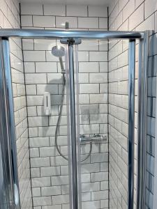 a shower in a bathroom with white tiles at Most Easterly (North) in Pakefield