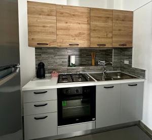 a kitchen with a stove and a sink at Sweet house Malpensa in Somma Lombardo