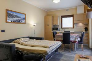 a small room with a bed and a kitchen at Chalet Armony in Livigno