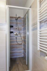 a shower in a bathroom with a wooden wall at Chalet Armony in Livigno
