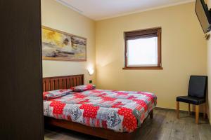 ein Schlafzimmer mit einem Bett, einem Stuhl und einem Fenster in der Unterkunft Chalet Armony in Livigno