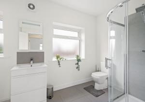 a white bathroom with a toilet and a window at 124 Vere Road in Peterborough
