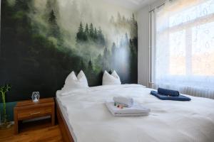 una camera da letto con un grande letto bianco con asciugamani sopra di Gruben Apartments 2 schlafzimmer a Schaffhausen