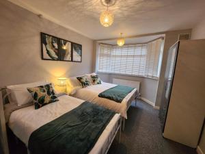 a bedroom with two beds and a window at Dale House in Stivichall