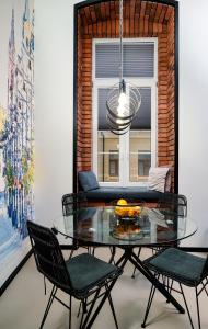 jadalnia ze szklanym stołem i krzesłami oraz oknem w obiekcie Loft Piotrkowska 37 w Łodzi