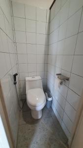 ein Badezimmer mit einem weißen WC in einer Kabine in der Unterkunft Kartika Lodge in Bengkok