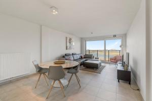 a living room with a table and a couch at Ontspannen aan zee app met frontaal zeezicht - 4p in Knokke-Heist