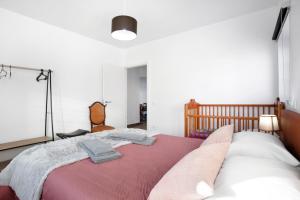 a bedroom with a bed with two towels on it at Casa da Padaria in Leiria