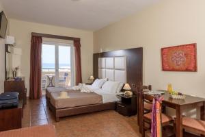 a bedroom with a bed and a table and a desk at Eurohotel Theo Hotel in Agia Marina Nea Kydonias
